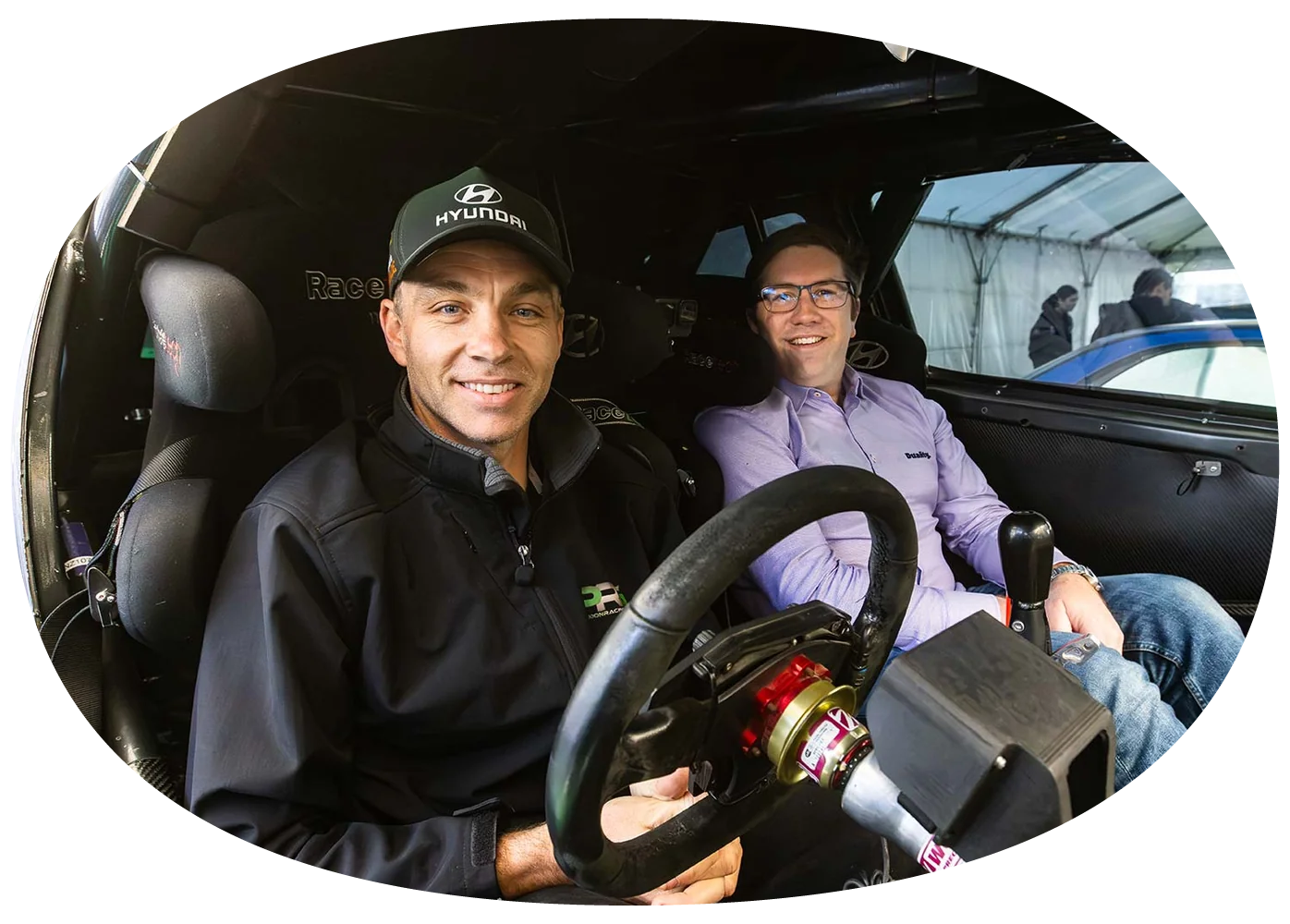 Hayden Paddon in the driver's seat of a rally car with Chris Hughes beside him